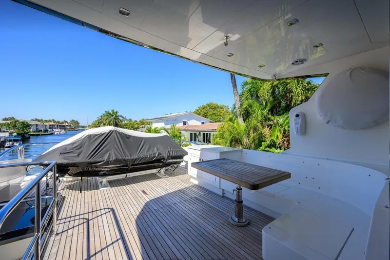  Yacht Photos Pics Luxury yacht deck with seating and table, Hampton Fly 2014 model, overlooking serene waterfront.
