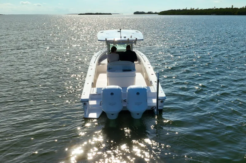  Yacht Photos Pics 2021 Everglades 273 Center Console boat cruising on sunlit water.