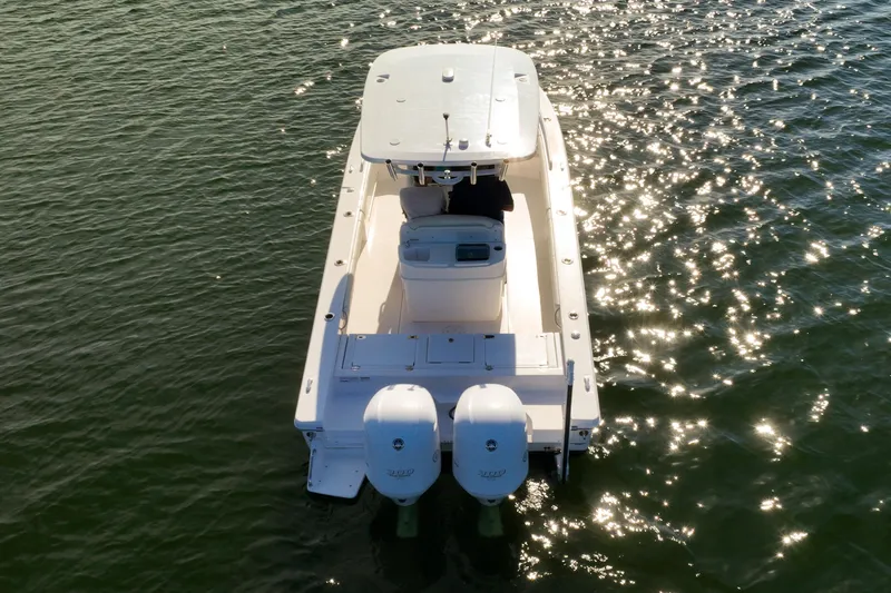  Yacht Photos Pics 2021 Everglades 273 Center Console boat on sparkling water, rear view.