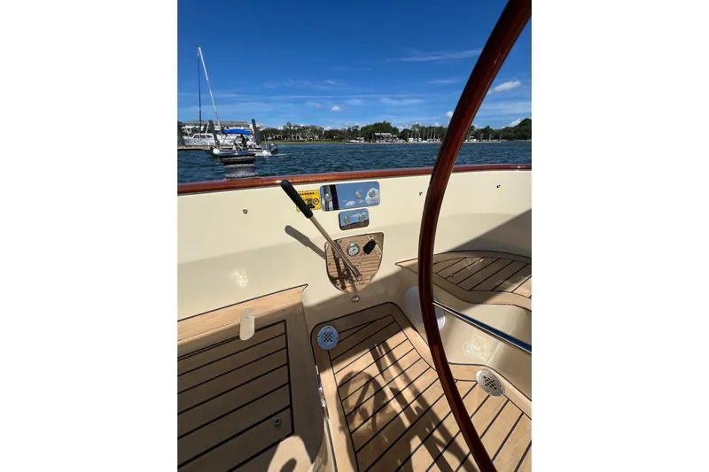 Yacht Photos Pics 2022 Leonardo Yachts Eagle 44 cockpit with wooden deck, steering wheel, and scenic water view.