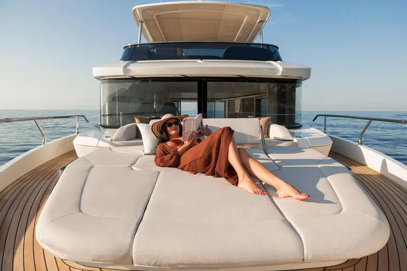 The Absolute Vibe Yacht Photos Pics Woman relaxing on Absolute Navetta 62 yacht, 2026 model, enjoying the sun and sea.