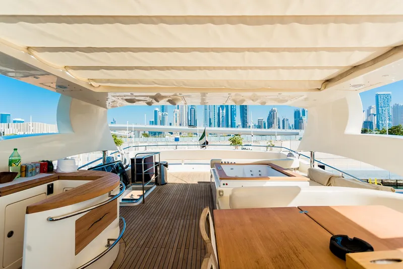  Yacht Photos Pics Luxurious Aicon 85 yacht deck with city skyline view, featuring a hot tub and dining area.