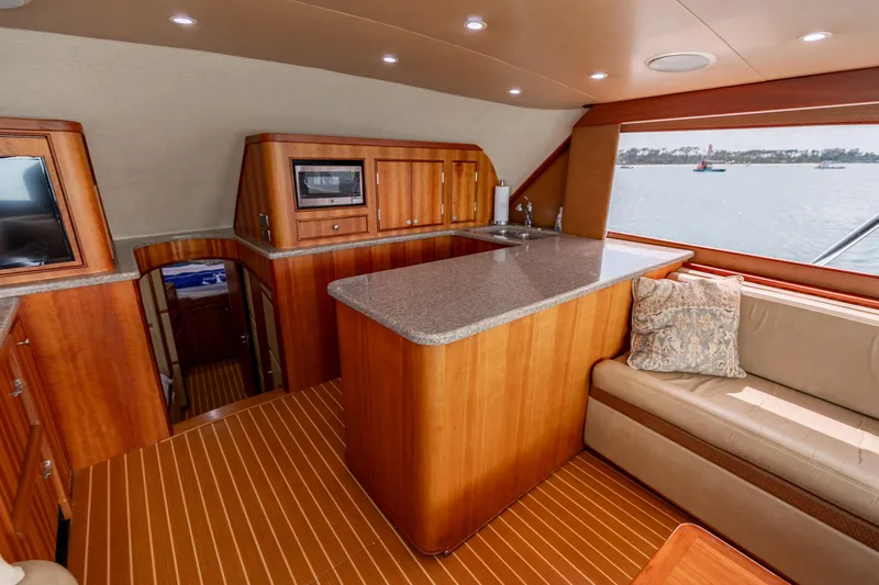 Honcho Yacht Photos Pics Luxurious interior of 2000 Custom Carolina Alex Willis Convertible yacht with wood finishes and ocean view.