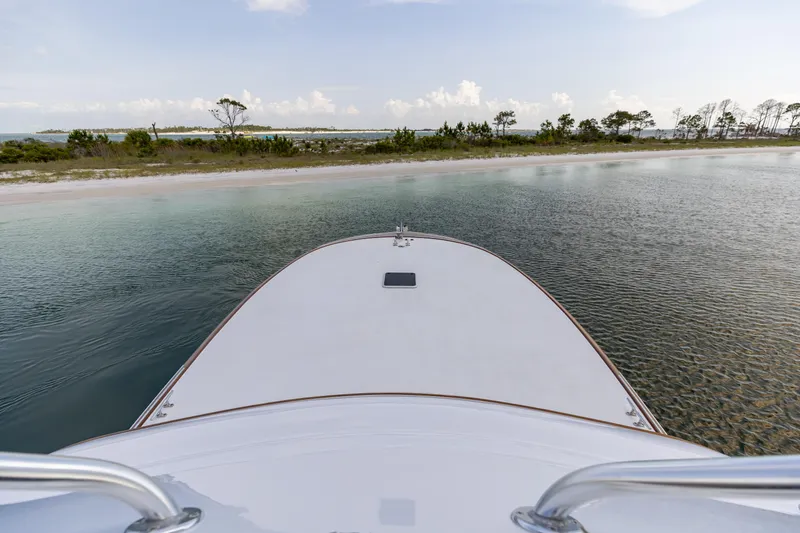 Honcho Yacht Photos Pics Bow view of 2000 Custom Carolina Alex Willis Convertible near a serene shoreline.