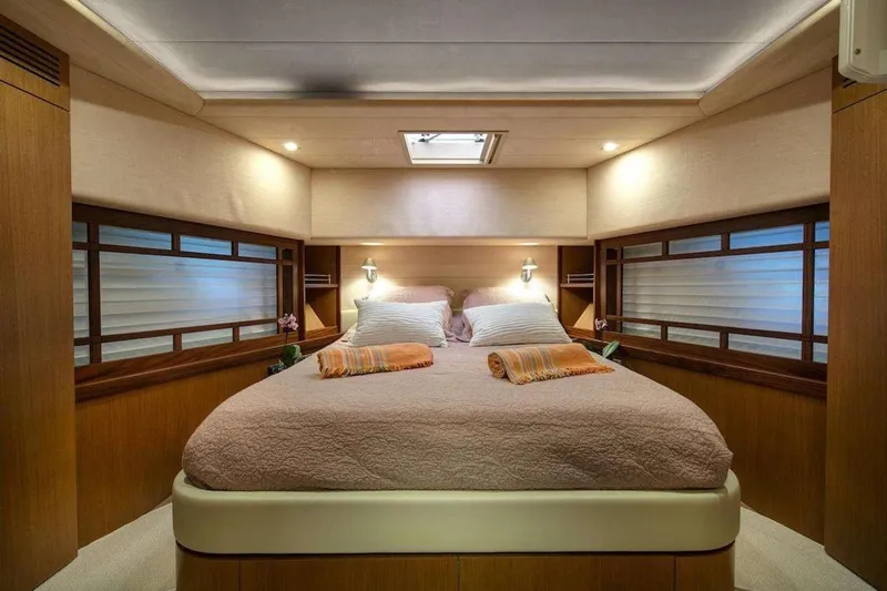  Yacht Photos Pics Luxurious bedroom interior of 2005 Ferretti 731 yacht with cozy bedding and ambient lighting.
