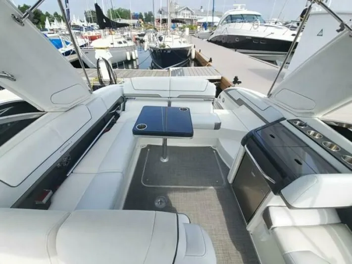  Yacht Photos Pics 2017 Formula 310SS boat interior with white seating, table, and docked yachts in background.