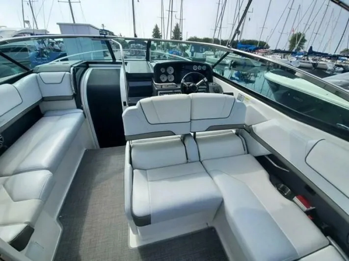  Yacht Photos Pics 2017 Formula 310SS boat interior with white seating and modern dashboard in a marina setting.