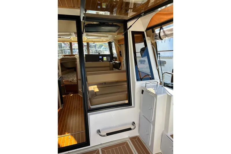 Two For The Road II Yacht Photos Pics Interior view of 2020 Ranger Tugs R-29 boat, featuring seating and wood flooring.