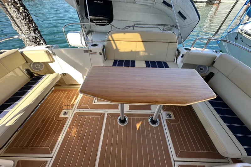 Two For The Road II Yacht Photos Pics 2020 Ranger Tugs R-29 boat interior with wooden table and cushioned seating.