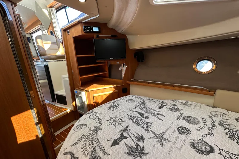Two For The Road II Yacht Photos Pics Cozy interior of 2020 Ranger Tugs R-29 with bed, TV, and wooden cabinetry.