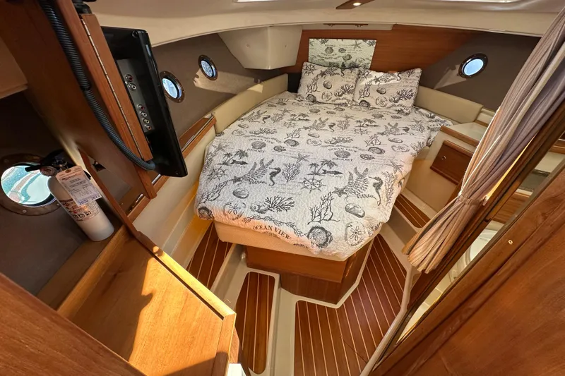 Two For The Road II Yacht Photos Pics 2020 Ranger Tugs R-29 cabin interior with cozy bed and nautical decor.