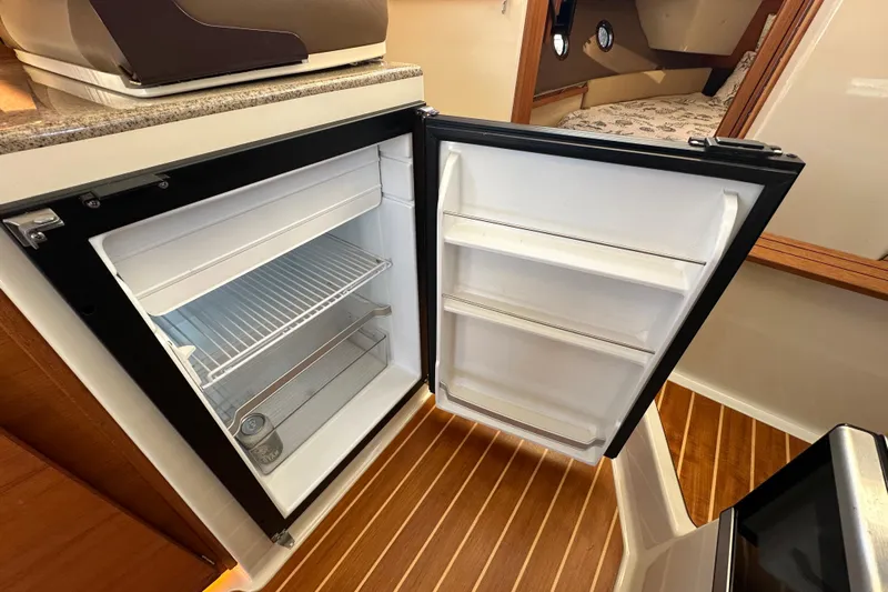 Two For The Road II Yacht Photos Pics Open refrigerator inside 2020 Ranger Tugs R-29 boat, showcasing interior storage space.