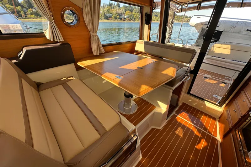Two For The Road II Yacht Photos Pics Interior of 2020 Ranger Tugs R-29 with wood accents and seating, overlooking water.