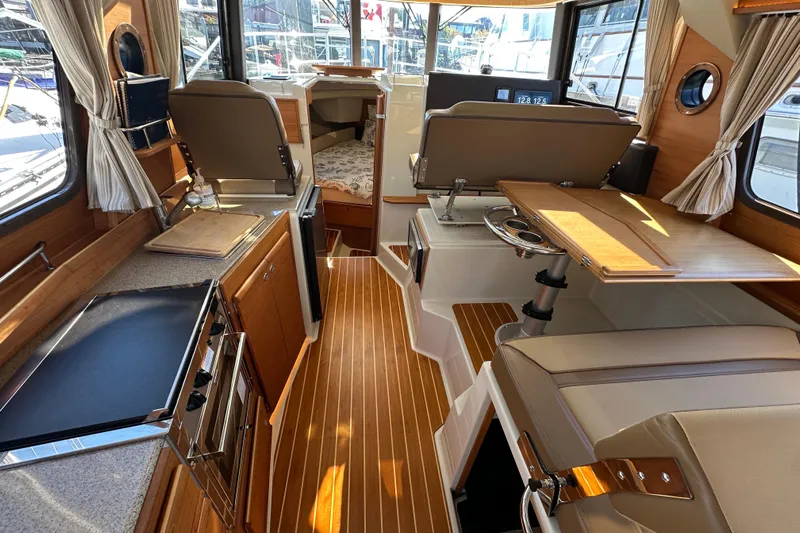 Two For The Road II Yacht Photos Pics Interior of 2020 Ranger Tugs R-29 boat with wood accents and seating area.