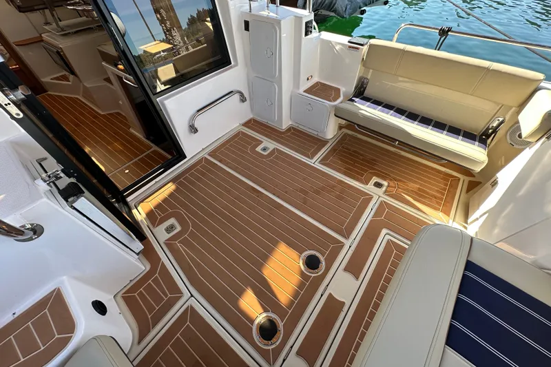 Two For The Road II Yacht Photos Pics 2020 Ranger Tugs R-29 boat interior with teak flooring and cushioned seating.