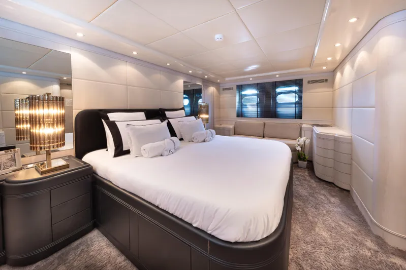 Lauren V Yacht Photos Pics Luxurious bedroom interior of 1997 Mangusta 103 yacht with elegant decor and ambient lighting.