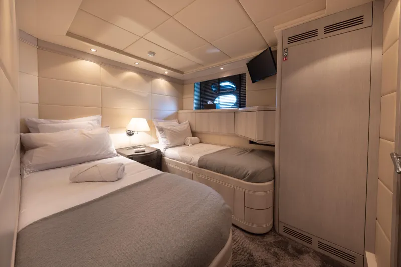 Lauren V Yacht Photos Pics Luxurious cabin interior of 1997 Mangusta 103 yacht with twin beds and modern decor.
