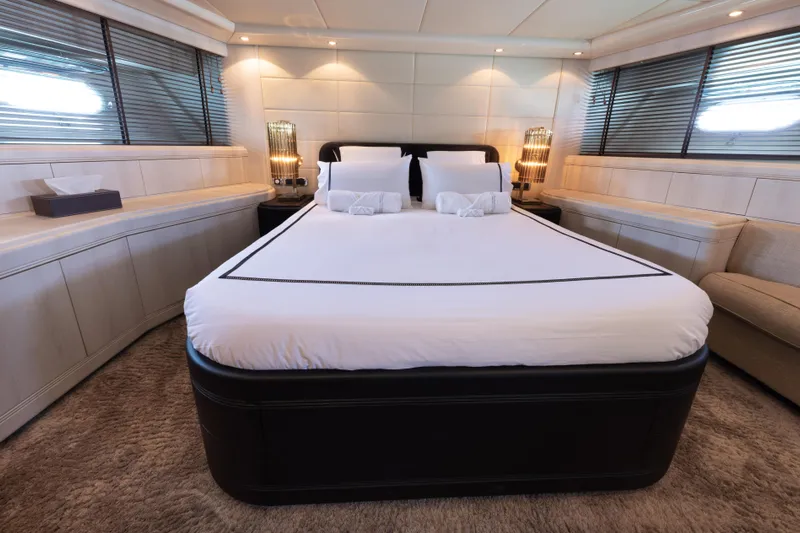 Lauren V Yacht Photos Pics Luxurious bedroom interior of 1997 Mangusta 103 yacht with elegant bedding and ambient lighting.
