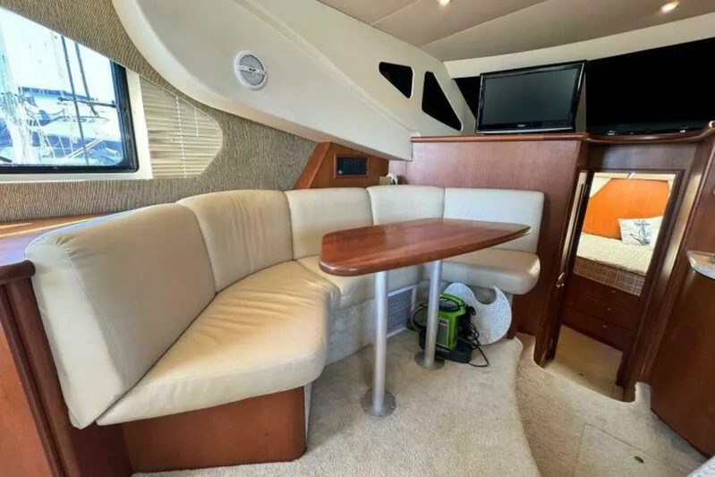  Yacht Photos Pics Interior of 2004 Silverton 35 Motor Yacht with cozy seating and wooden table.