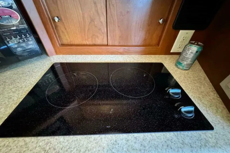  Yacht Photos Pics Glass cooktop in 2004 Silverton 35 Motor Yacht kitchen, with wooden cabinetry and countertop.