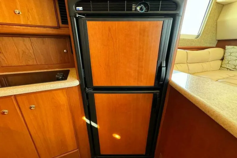  Yacht Photos Pics 2004 Silverton 35 Motor Yacht interior with wooden cabinetry and compact refrigerator.