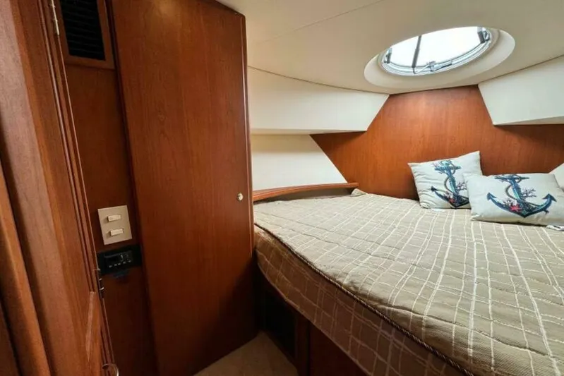  Yacht Photos Pics 2004 Silverton 35 Motor Yacht cabin with bed, anchor-themed pillows, and wooden interior.