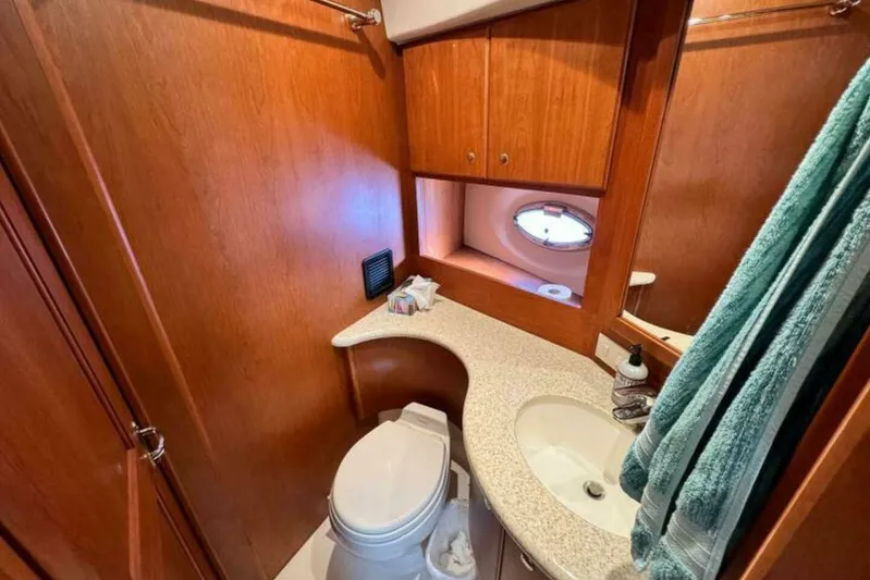  Yacht Photos Pics 2004 Silverton 35 Motor Yacht bathroom with wood cabinetry and porthole window.