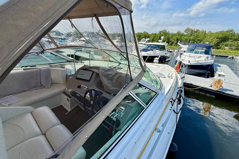  Yacht Photos Pics 2004 Cruisers Yachts 3672 at marina, featuring cockpit and helm, surrounded by other boats.