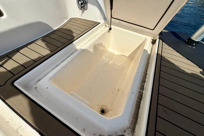  Yacht Photos Pics Open storage compartment on 2004 Cruisers Yachts 3672, featuring teak flooring and water access.