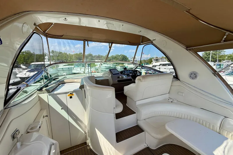  Yacht Photos Pics 2004 Cruisers Yachts 3672 interior with white seating and helm, docked at marina.