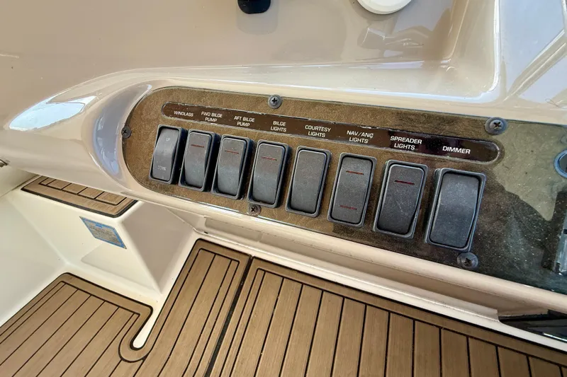  Yacht Photos Pics Control panel of a 2004 Cruisers Yachts 3672 with various switches and teak flooring.