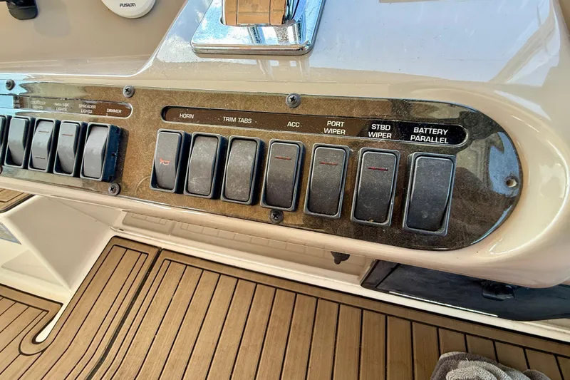  Yacht Photos Pics Control panel of a 2004 Cruisers Yachts 3672 with labeled switches and teak flooring.