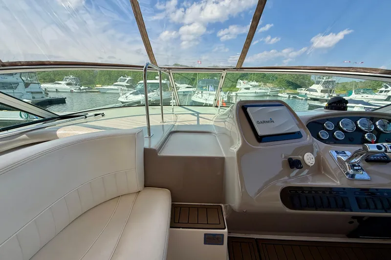  Yacht Photos Pics 2004 Cruisers Yachts 3672 helm with Garmin navigation, docked in a marina under blue skies.