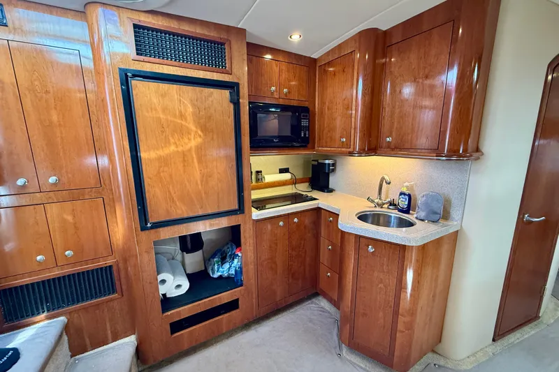  Yacht Photos Pics 2004 Cruisers Yachts 3672 galley with wood cabinetry, sink, microwave, and refrigerator.