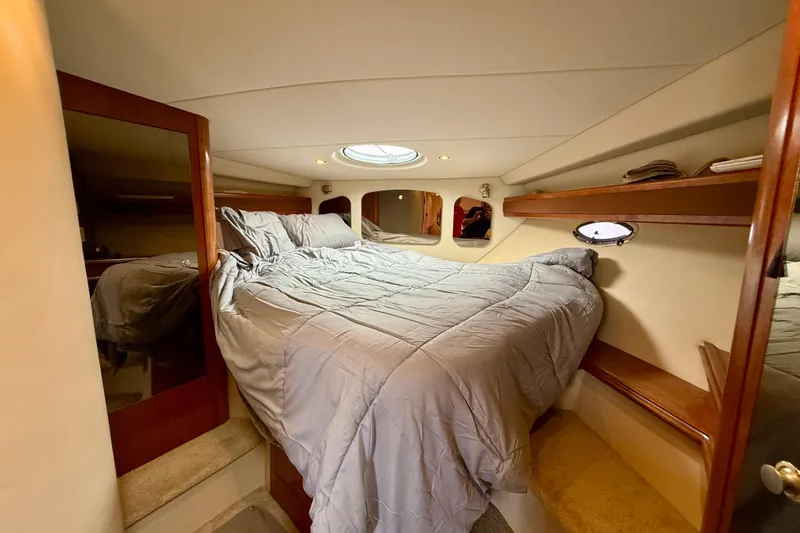  Yacht Photos Pics Luxurious 2004 Cruisers Yachts 3672 cabin interior with cozy bed and elegant wood accents.