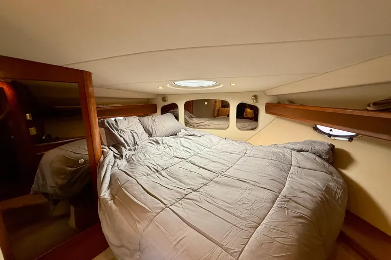  Yacht Photos Pics Luxurious cabin interior of 2004 Cruisers Yachts 3672 with cozy bed and elegant wood accents.
