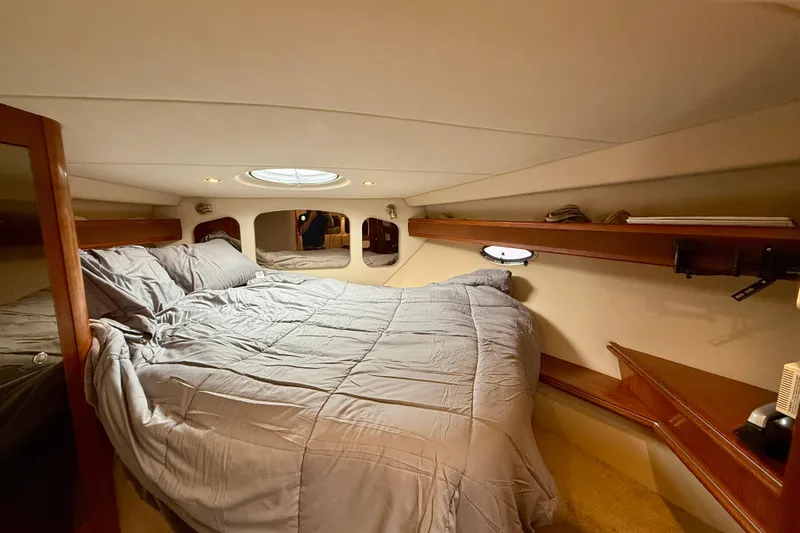  Yacht Photos Pics Luxurious cabin interior of 2004 Cruisers Yachts 3672 with cozy bed and elegant wood finishes.