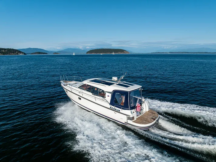 Keokuk Yacht Photos Pics Nimbus 365 Coupe 2020 cruising on open water with scenic island backdrop.