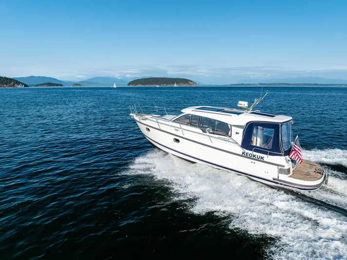 Keokuk Yacht Photos Pics Nimbus 365 Coupe 2020 cruising on open water with scenic island backdrop.