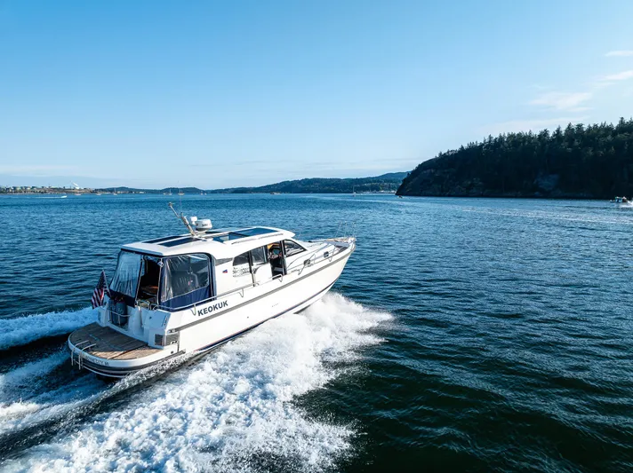 Keokuk Yacht Photos Pics Nimbus 365 Coupe 2020 cruising on open water, scenic coastal backdrop.