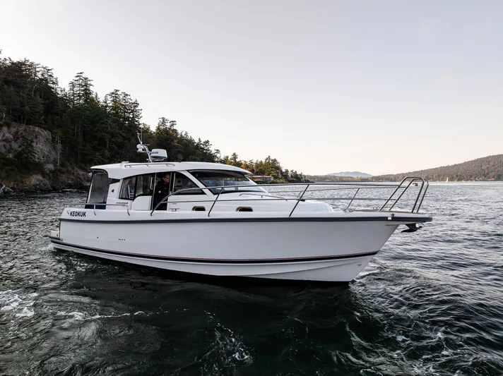 Keokuk Yacht Photos Pics 2020 Nimbus 365 Coupe cruising on scenic waters near forested shoreline.