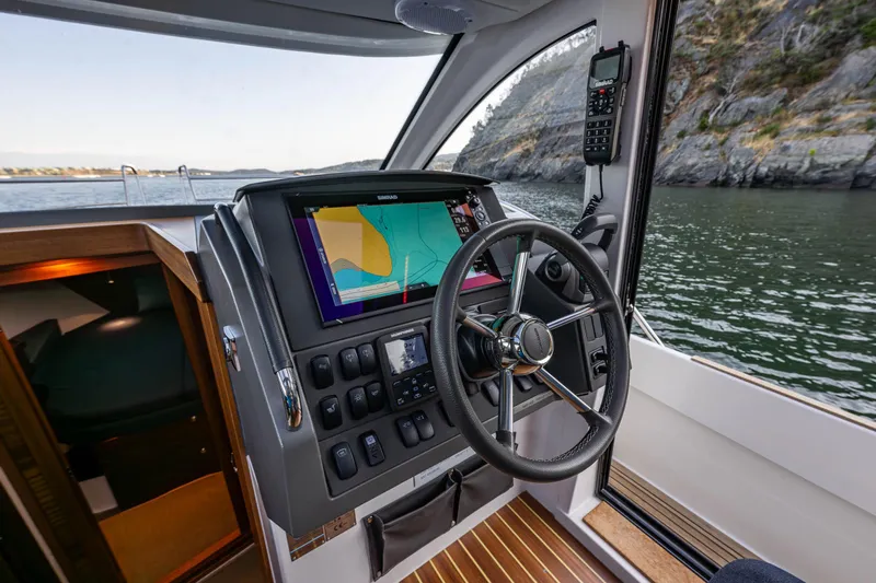 Keokuk Yacht Photos Pics 2020 Nimbus 365 Coupe helm with navigation system and steering wheel, overlooking scenic waters.