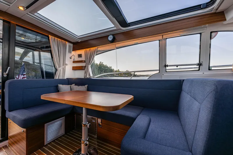 Keokuk Yacht Photos Pics Interior of 2020 Nimbus 365 Coupe with blue seating and wooden table.