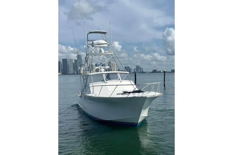  Yacht Photos Pics 1993 Buddy Davis 38 Express boat on water with city skyline background.