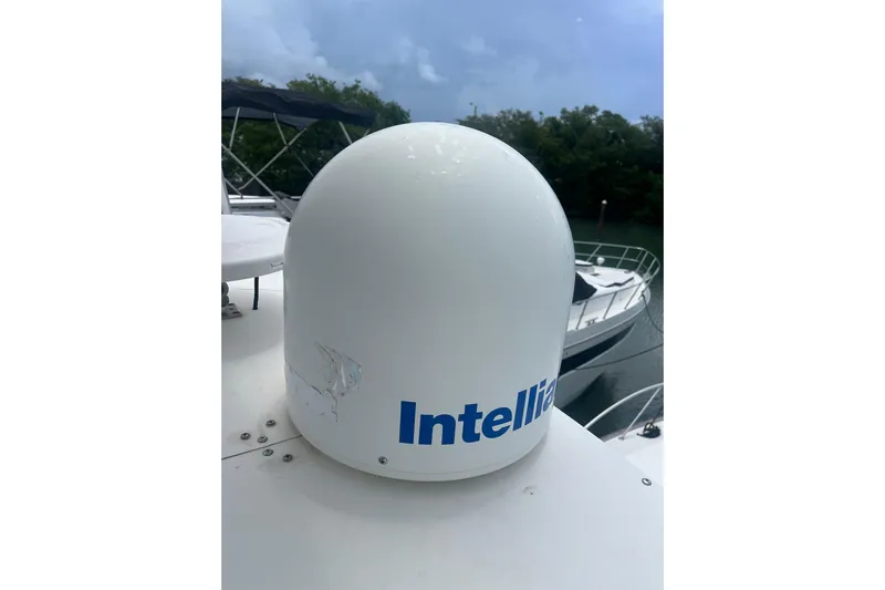  Yacht Photos Pics Satellite dome on 1993 Buddy Davis 38 Express boat, docked near trees and water.