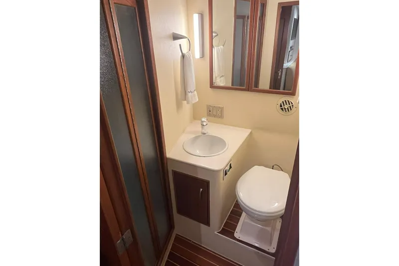  Yacht Photos Pics Compact bathroom in 1993 Buddy Davis 38 Express boat with sink, toilet, and mirror.
