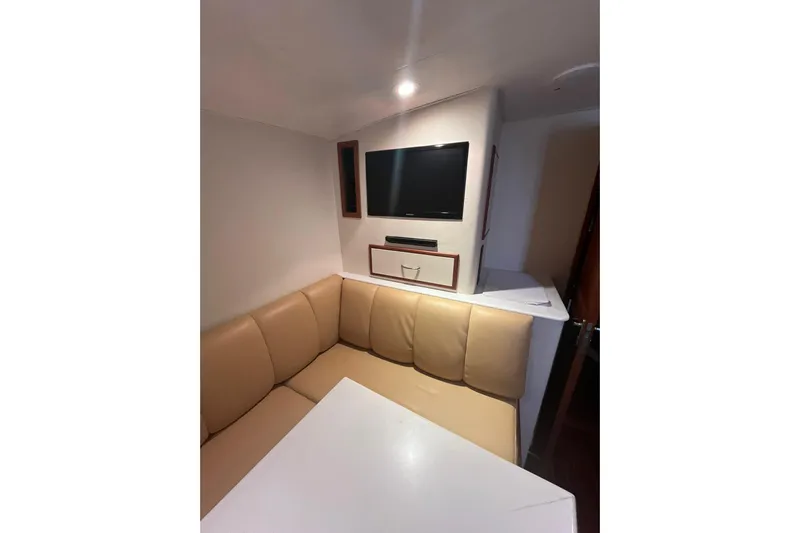  Yacht Photos Pics Interior of 1993 Buddy Davis 38 Express yacht with beige seating and wall-mounted TV.