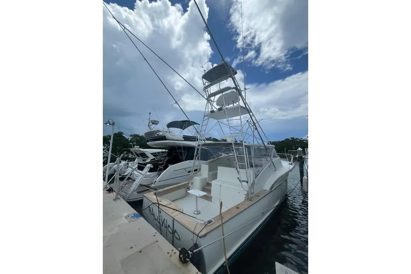  Yacht Photos Pics 1993 Buddy Davis 38 Express boat docked under cloudy sky.