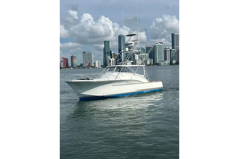  Yacht Photos Pics 1993 Buddy Davis 38 Express boat on water with city skyline background.
