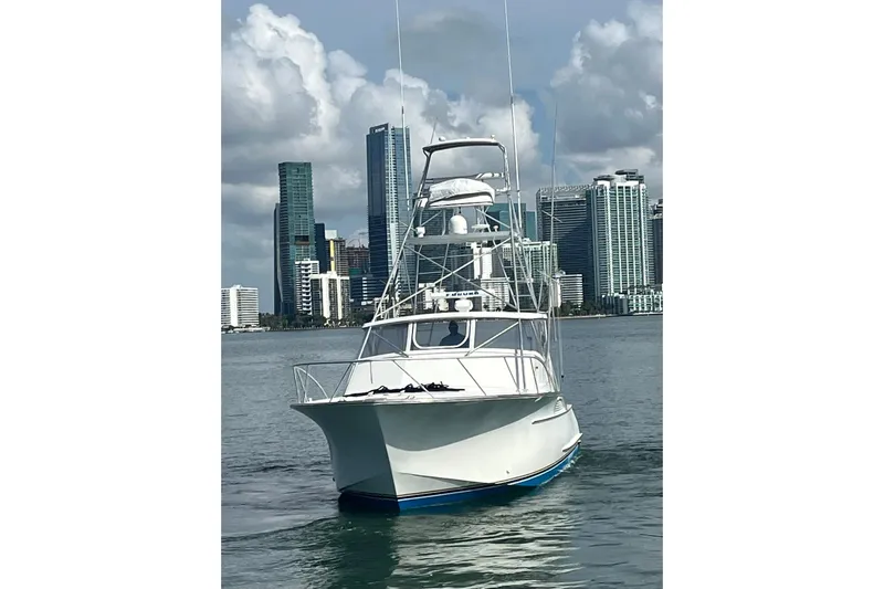  Yacht Photos Pics 1993 Buddy Davis 38 Express boat on water with city skyline backdrop.